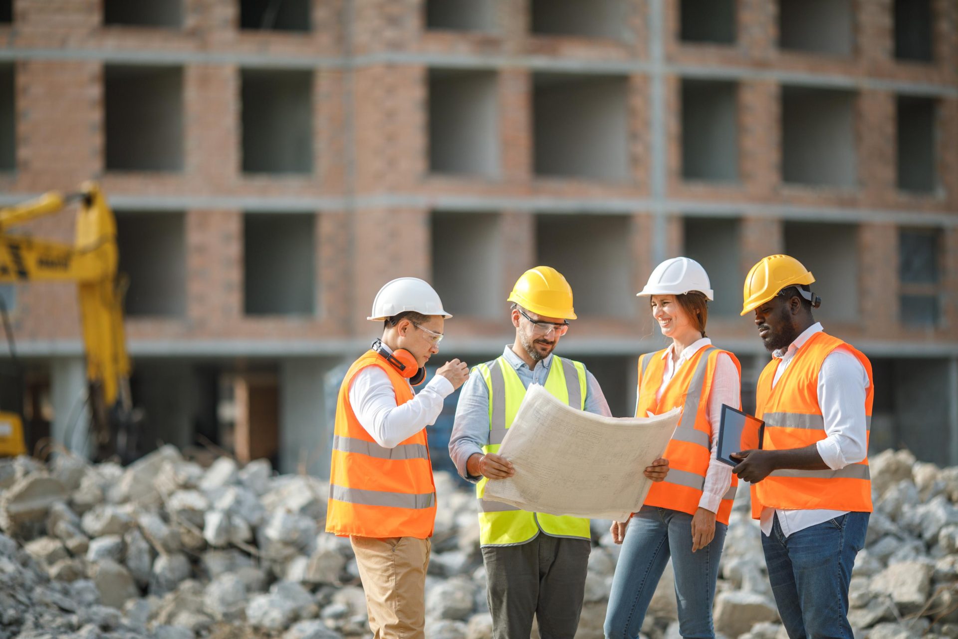 Group of 4 construction engineers on the field